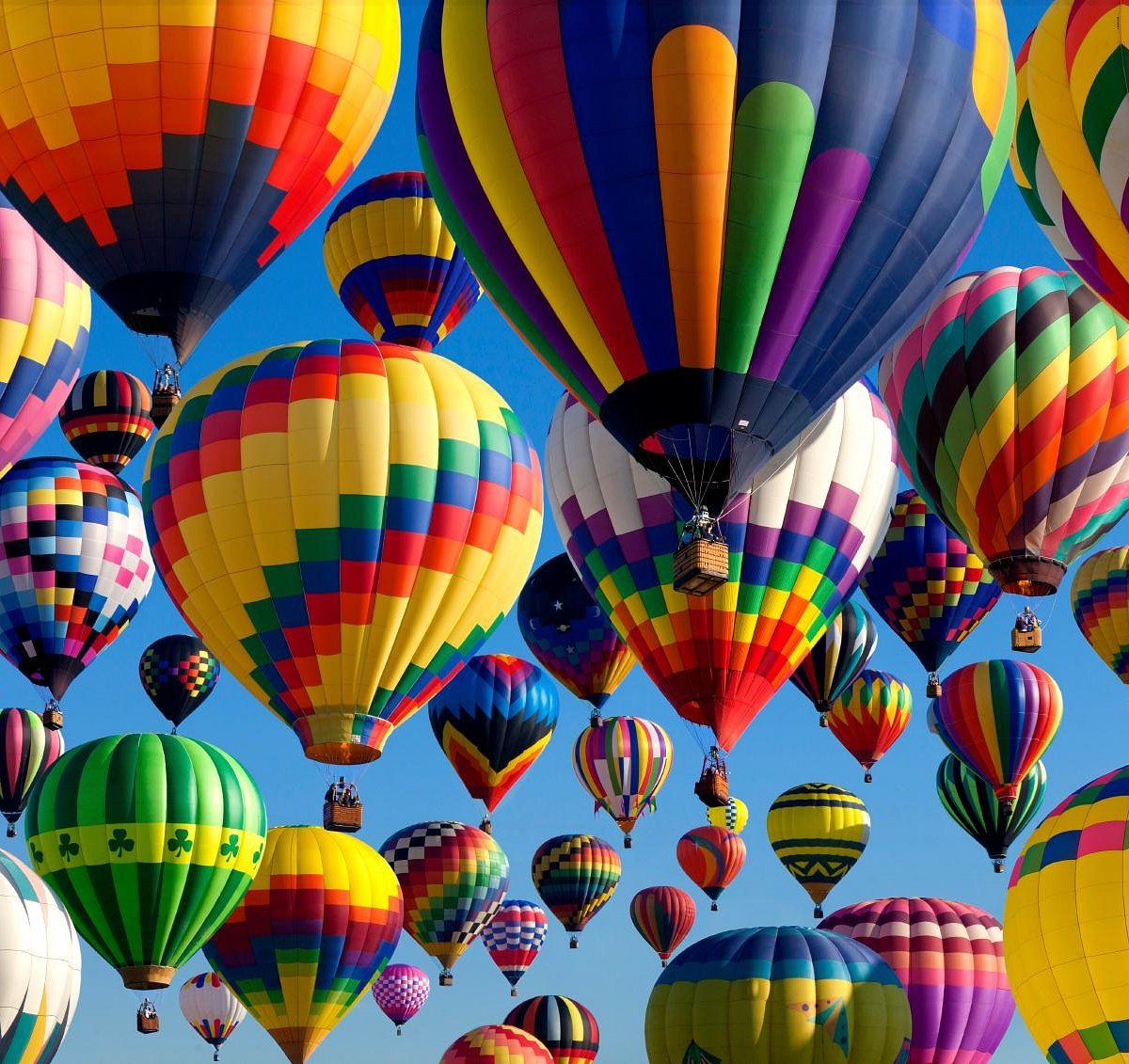 Hundreds of hot air balloons filling the sky during mass ascension at Albuquerque Balloon Fiesta