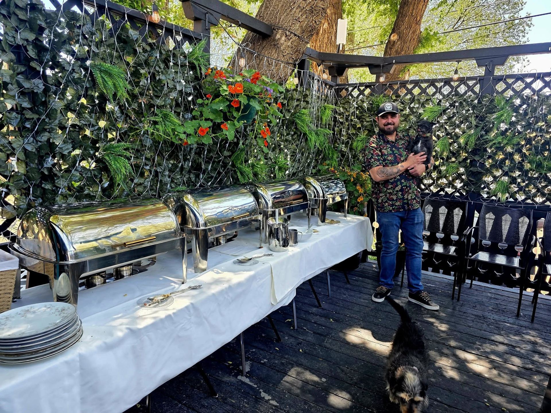 Ryan setting up the patio with chafing dishes for a private event